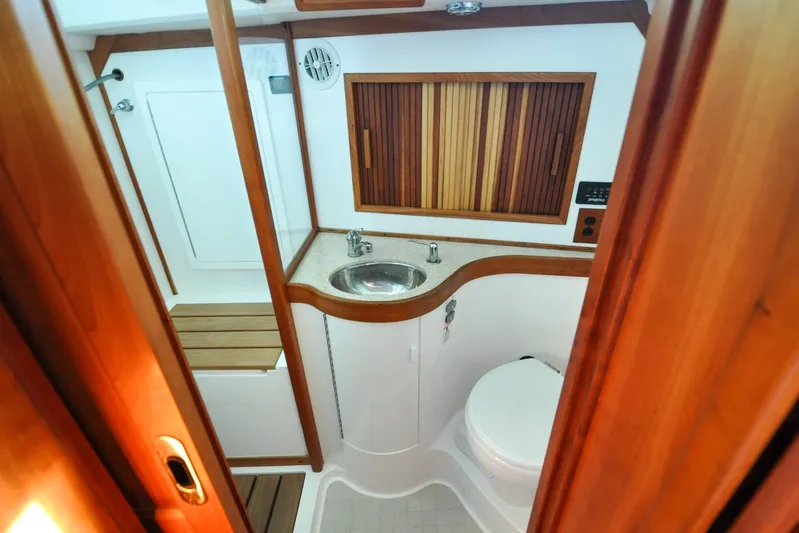 Jezebel Yacht Photos Pics 2004 Sabre 426 yacht bathroom with wooden accents, sink, and toilet.