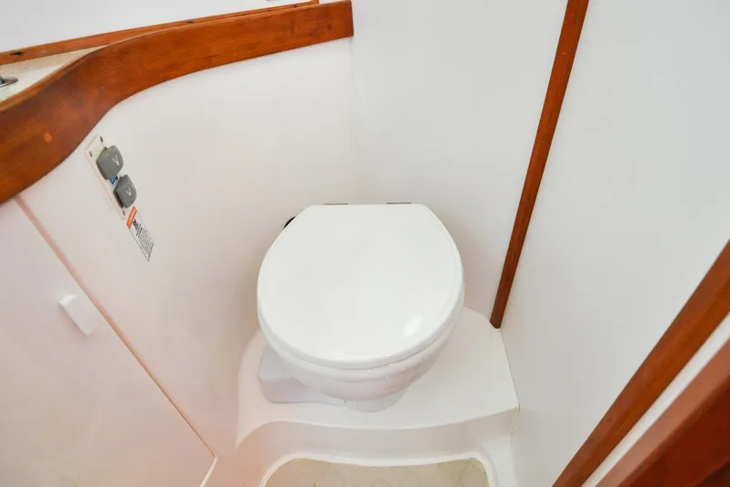 Jezebel Yacht Photos Pics 2004 Sabre 426 yacht bathroom with white toilet and wooden trim.