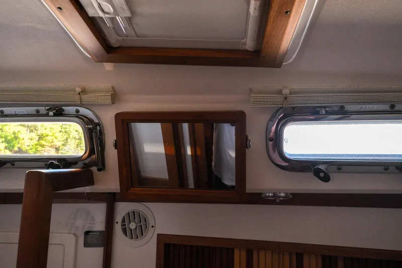 Jezebel Yacht Photos Pics Interior of a 2004 Sabre 426 yacht with portholes and wooden accents.