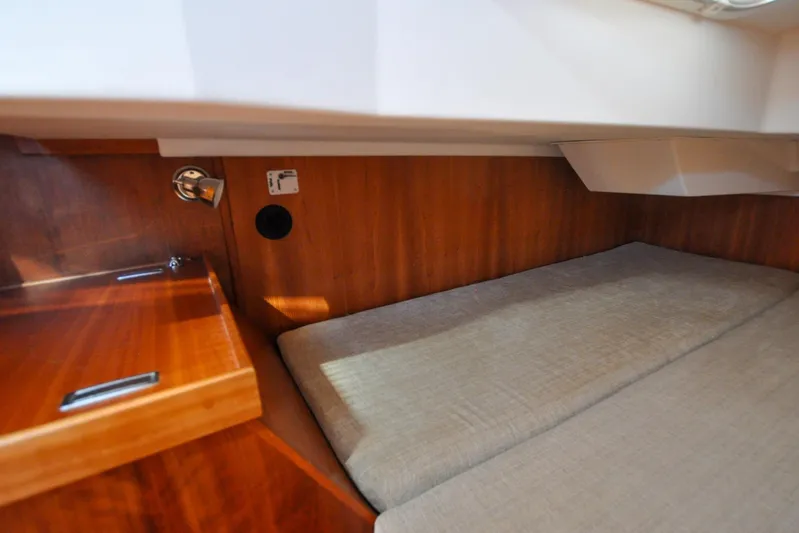 Jezebel Yacht Photos Pics 2004 Sabre 426 yacht interior with wooden cabinetry and cushioned sleeping area.