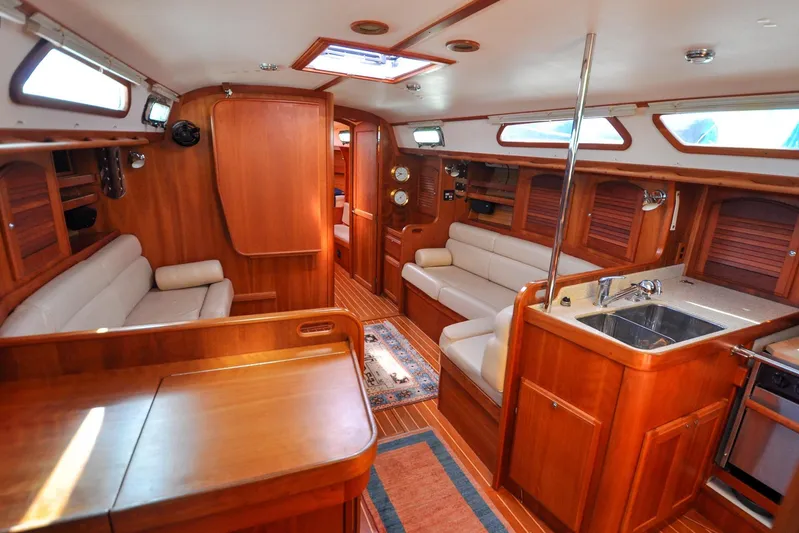 Jezebel Yacht Photos Pics Luxurious 2004 Sabre 426 yacht interior with wooden finish, cozy seating, and modern kitchen amenities.