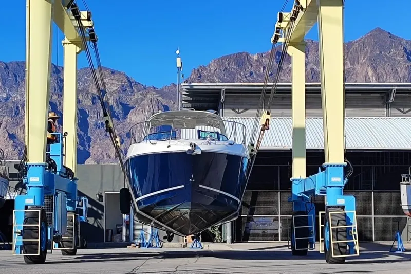  Yacht Photos Pics 2011 Sea Ray 370 Sundancer yacht lifted by crane in marina with mountain backdrop.