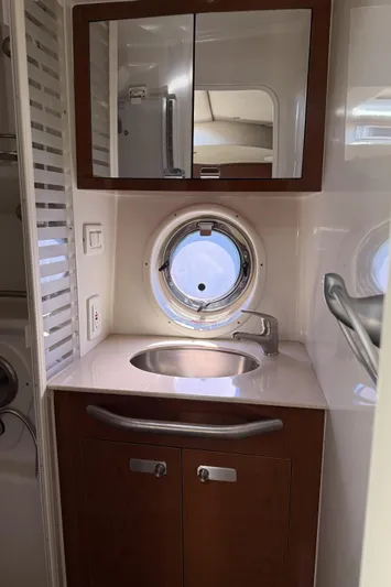  Yacht Photos Pics 2011 Sea Ray 370 Sundancer bathroom with sink, mirror, and porthole window.