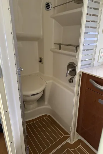  Yacht Photos Pics 2011 Sea Ray 370 Sundancer bathroom with toilet, shelves, and wooden floor accents.