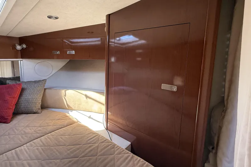  Yacht Photos Pics Interior cabin of 2011 Sea Ray 370 Sundancer with wood paneling and cozy bedding.