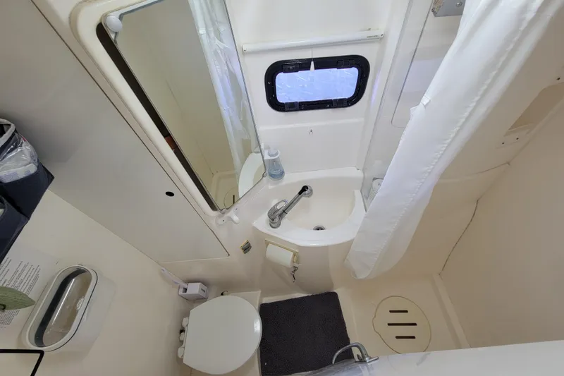 Finding Anemoi Yacht Photos Pics Compact bathroom in a 2014 Leopard 39 yacht, featuring a sink, toilet, and shower.