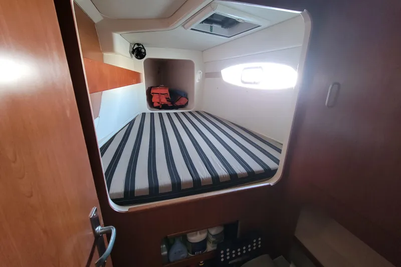 Finding Anemoi Yacht Photos Pics Cabin interior of 2014 Leopard 39 yacht with striped bedding and storage space.