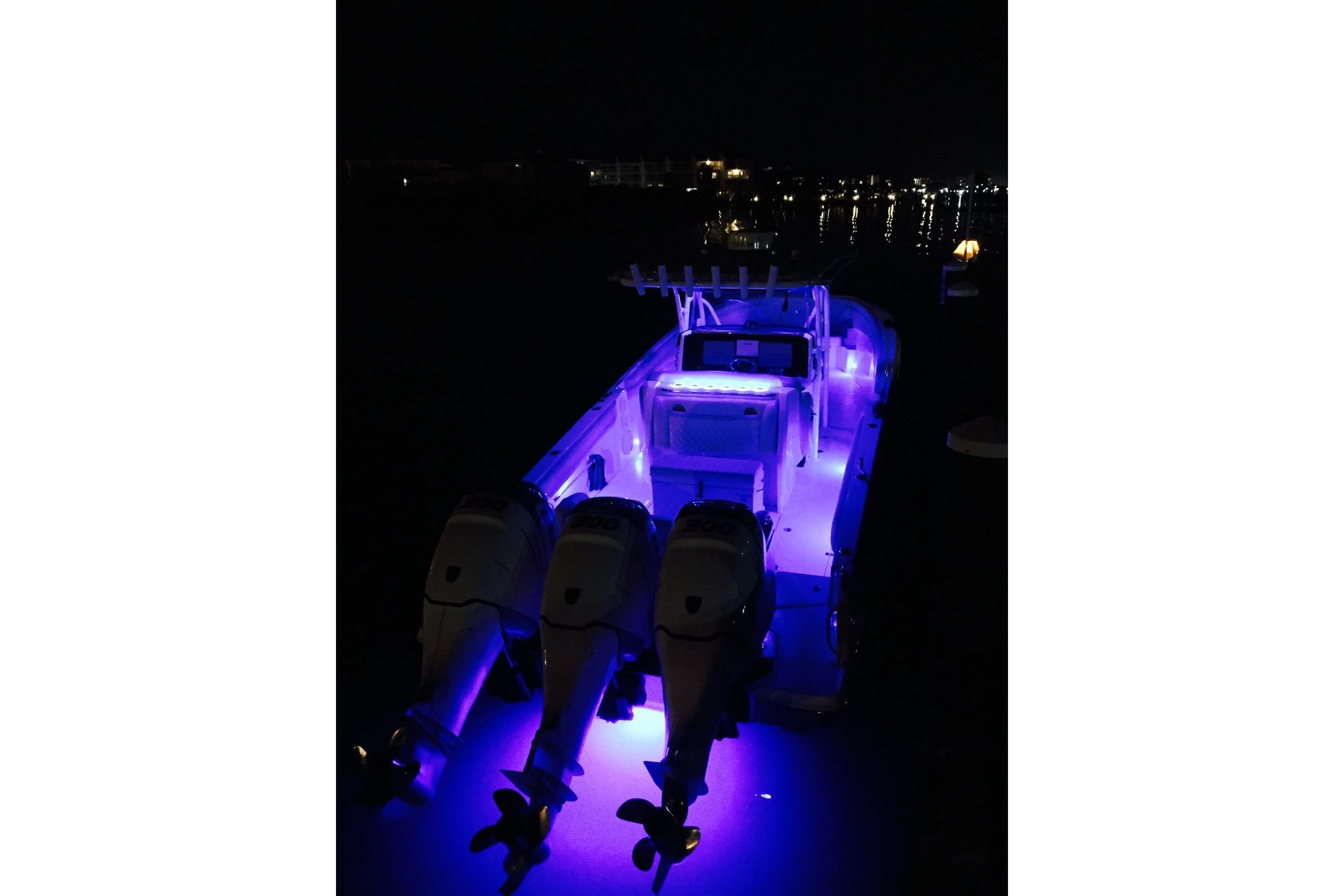 2014 Nor-Tech 340 Sport Center Console boat illuminated with blue lights at night.