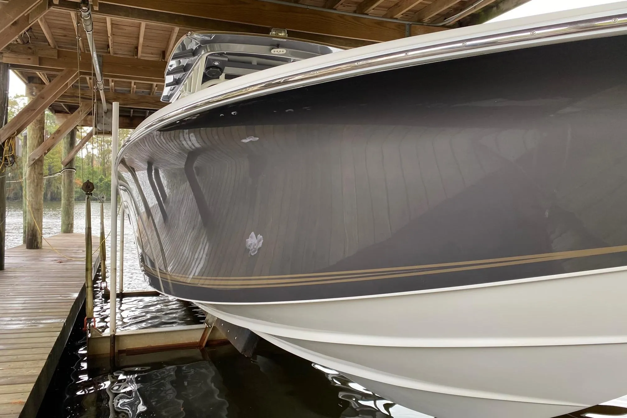 2014 Nor-Tech 340 Sport Center Console boat docked under wooden shelter.