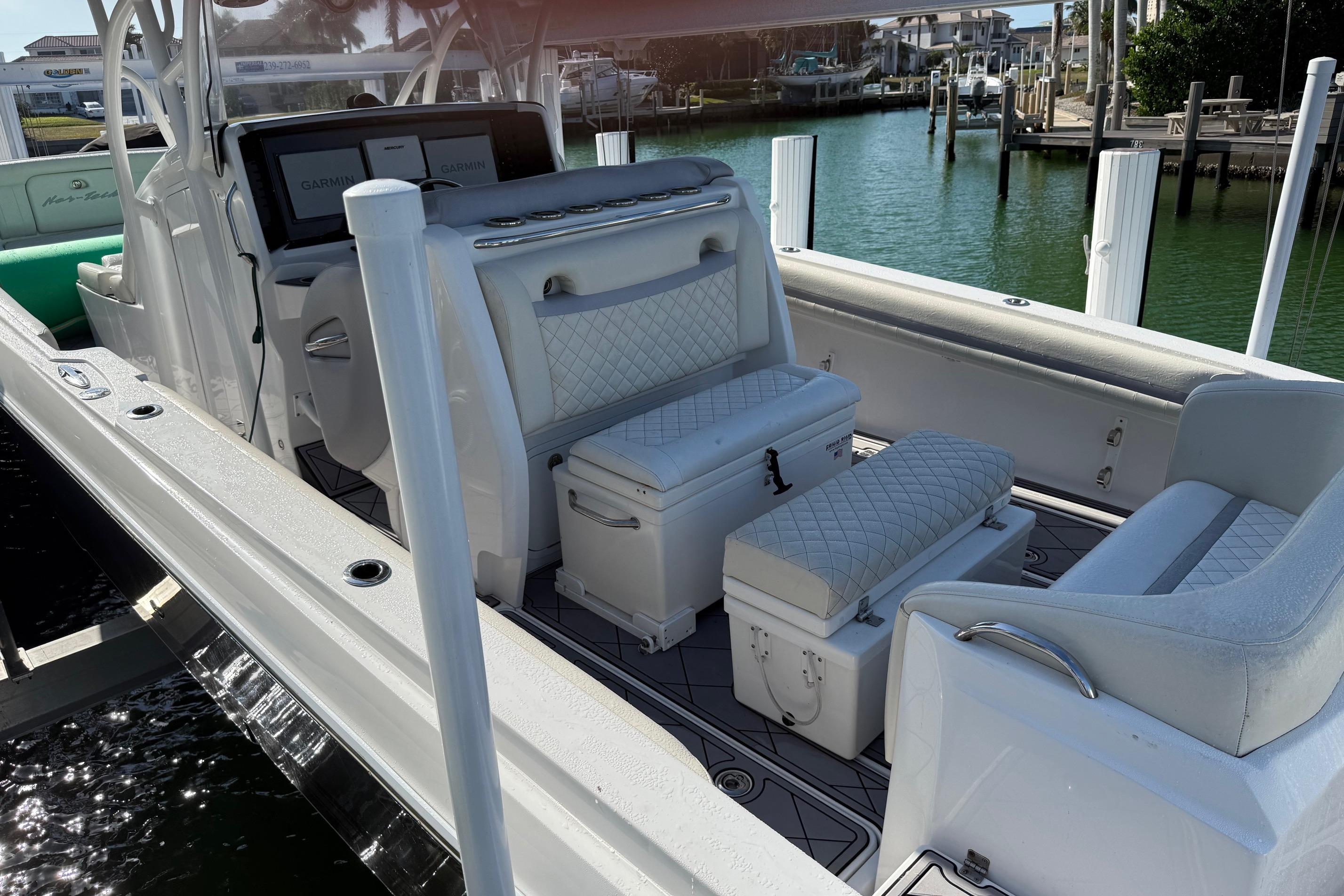 2014 Nor-Tech 340 Sport Center Console boat interior with white seating and Garmin displays.