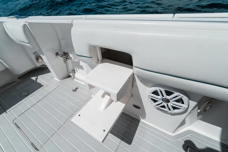  Yacht Photos Pics 2022 Intrepid 407 Nomad FE boat interior with fold-out seat and speaker.