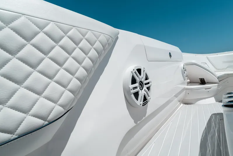  Yacht Photos Pics 2022 Intrepid 407 Nomad FE interior with quilted upholstery and speaker, under clear blue sky.