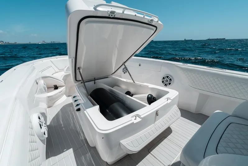  Yacht Photos Pics 2022 Intrepid 407 Nomad FE boat with open storage compartment on the ocean.