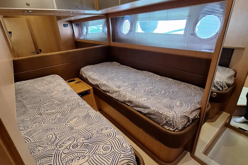 Vida II Yacht Photos Pics Interior of 2007 Riva 68 Ego yacht with twin beds and porthole windows.
