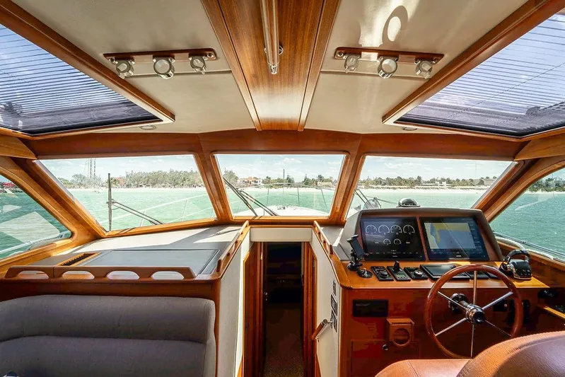 Compass Yacht Photos Pics Interior view of 2020 Grand Banks 44 Eastbay SX yacht cockpit with wooden accents and navigation equipment.
