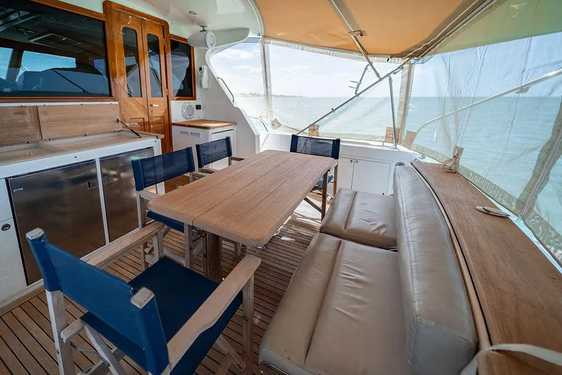 Compass Yacht Photos Pics 2020 Grand Banks 44 Eastbay SX yacht interior with dining area, wooden table, and ocean view.