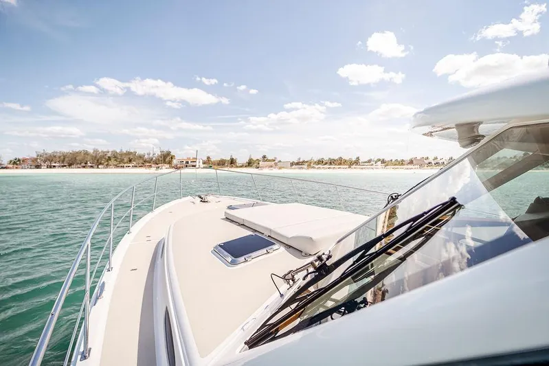 Compass Yacht Photos Pics Grand Banks 44 Eastbay SX yacht cruising near a scenic coastline under a clear blue sky.