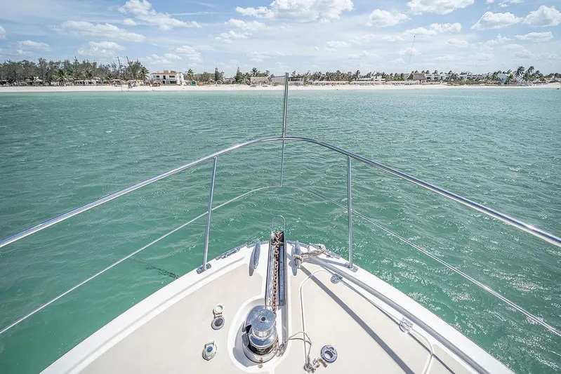 Compass Yacht Photos Pics Bow view of 2020 Grand Banks 44 Eastbay SX yacht approaching a tropical shoreline.