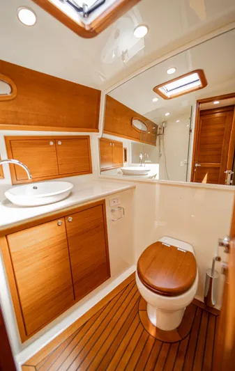 Compass Yacht Photos Pics Luxurious bathroom in 2020 Grand Banks 44 Eastbay SX yacht with wooden accents and modern fixtures.