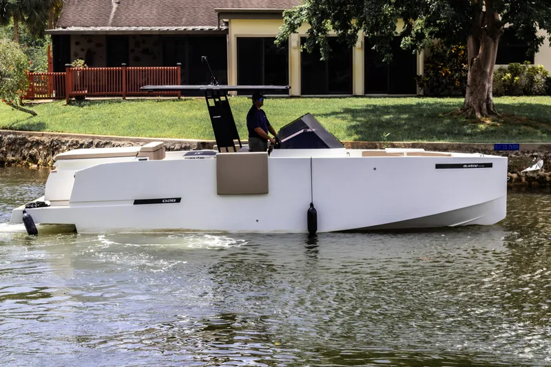  Yacht Photos Pics 2024 De Antonio Yachts D28 Open cruising on a calm waterway near a house.