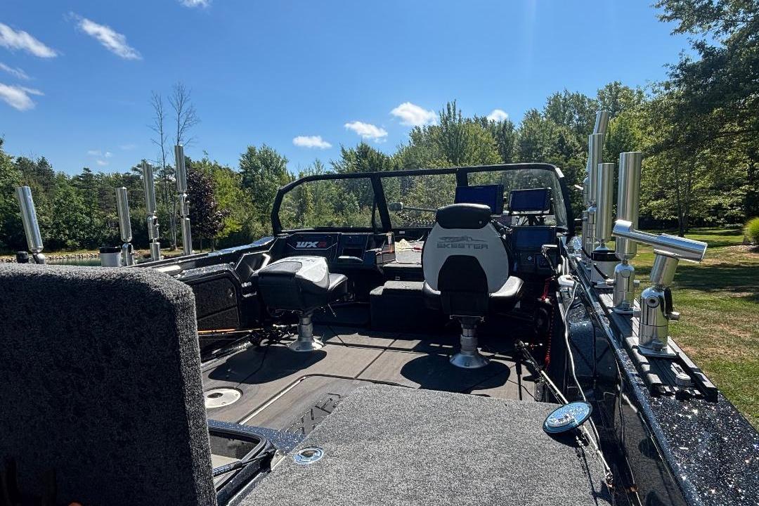 2025 Skeeter WXR2260 boat interior with fishing rod holders, under a clear blue sky.