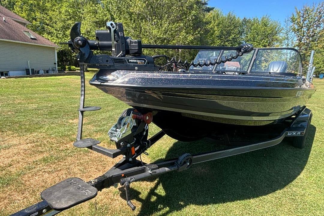 2025 Skeeter WXR2260 boat on trailer, parked on grass, with Minn Kota trolling motor.