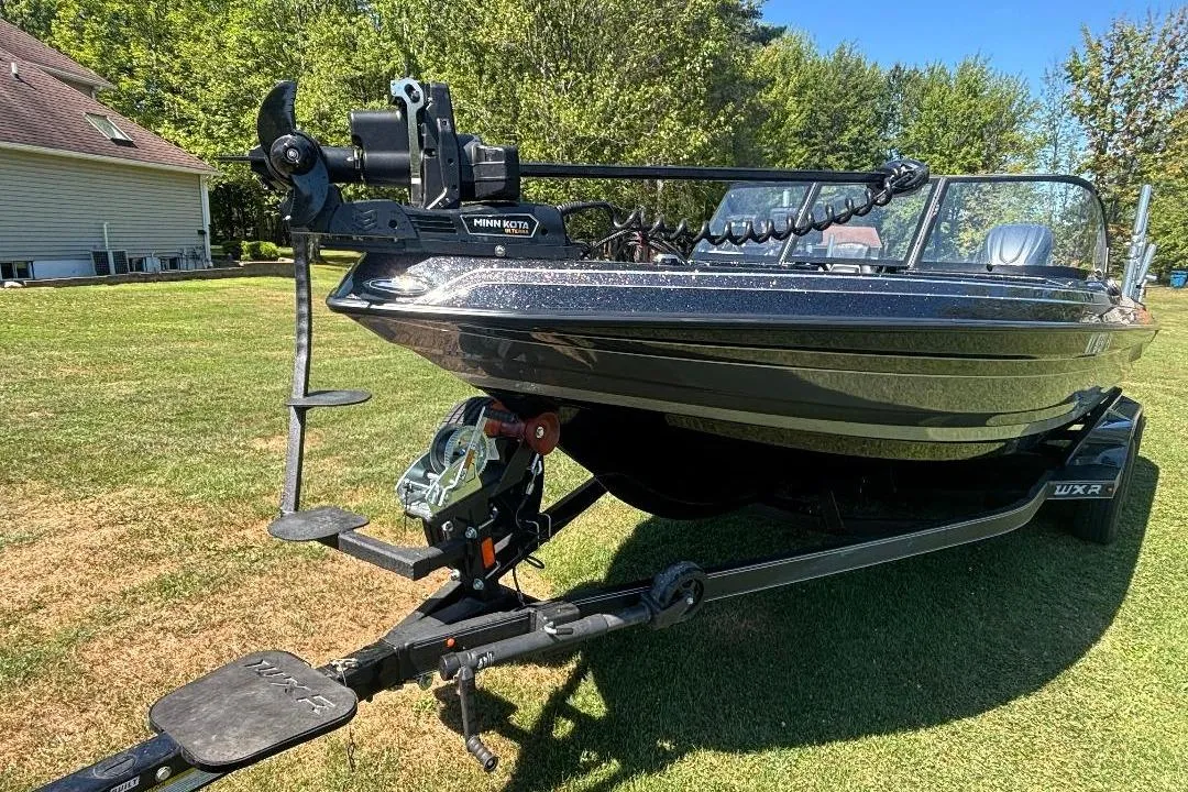 2025 Skeeter WXR2260 boat on trailer, parked on grass, with Minn Kota trolling motor.