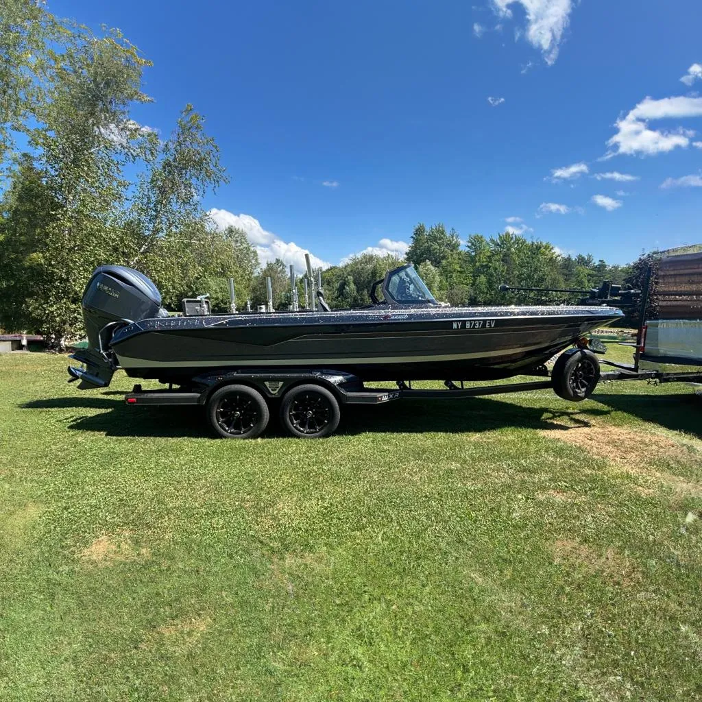 2025 Skeeter WXR2260 boat on trailer, parked on grass under clear blue sky.