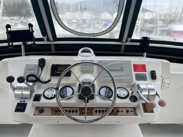  Yacht Photos Pics Helm of 2000 Mainship 430 Trawler with Garmin navigation system and classic controls.
