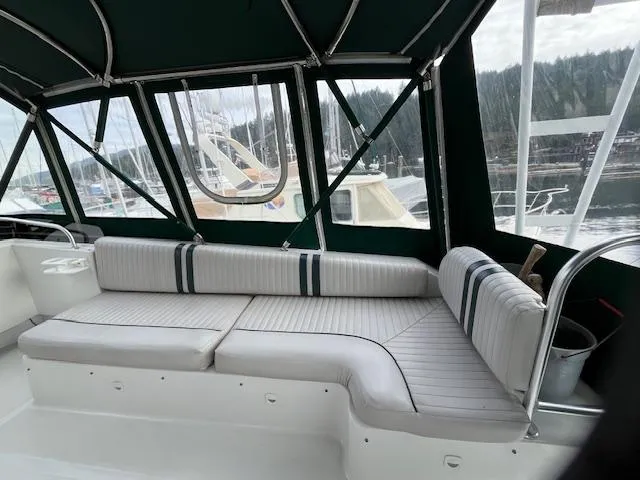  Yacht Photos Pics 2000 Mainship 430 Trawler interior with cushioned seating and marina view.