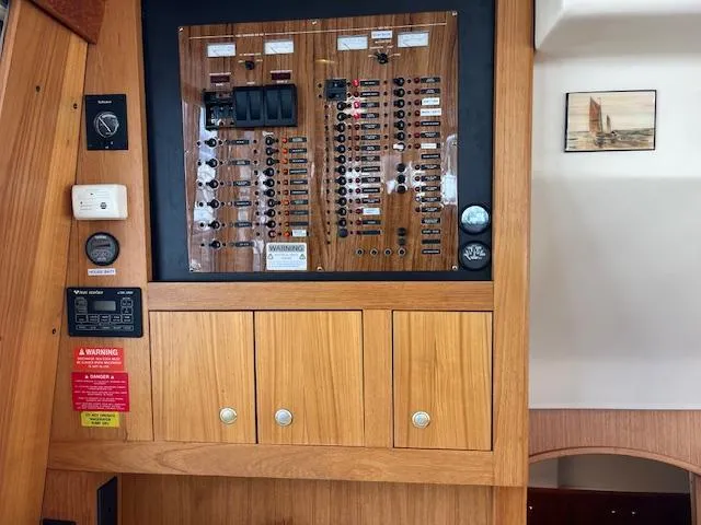  Yacht Photos Pics Electrical panel of a 2000 Mainship 430 Trawler with wooden cabinetry.