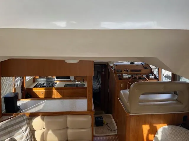  Yacht Photos Pics Interior of 2000 Mainship 430 Trawler, featuring helm, seating, and kitchen area.