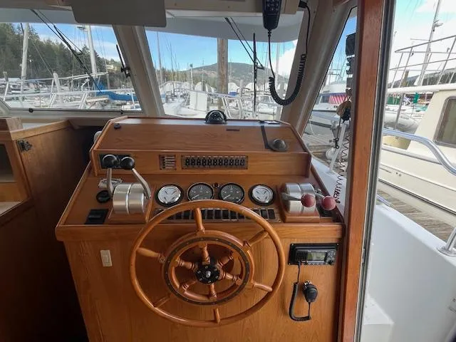  Yacht Photos Pics Helm of 2000 Mainship 430 Trawler with wooden steering wheel and navigation instruments.