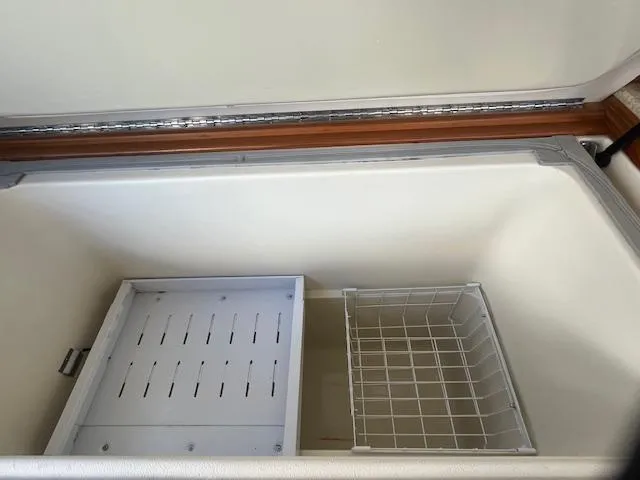  Yacht Photos Pics Open storage compartment on 2000 Mainship 430 Trawler, featuring wire basket and divider.