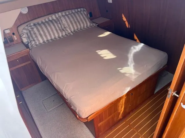  Yacht Photos Pics Cozy bedroom in 2000 Mainship 430 Trawler with wooden accents and striped bedding.