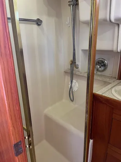  Yacht Photos Pics Shower area in 2000 Mainship 430 Trawler, featuring a compact design with chrome fixtures.