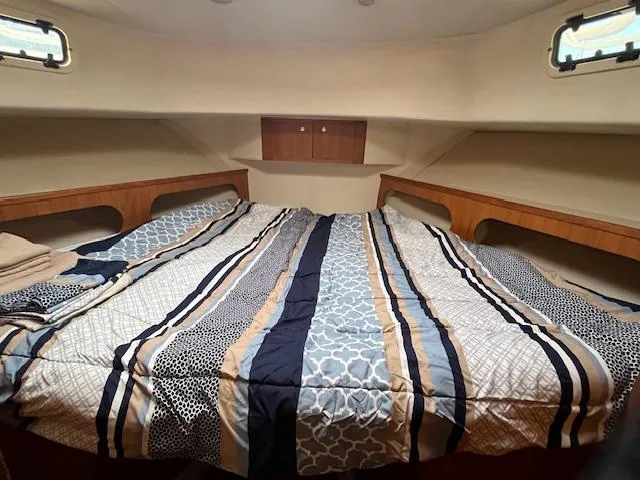  Yacht Photos Pics Cozy cabin interior of 2000 Mainship 430 Trawler with striped bedding.