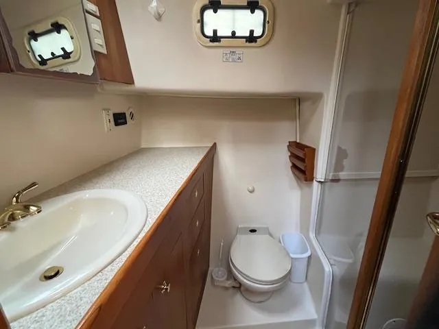  Yacht Photos Pics Bathroom interior of 2000 Mainship 430 Trawler with sink, toilet, and shower.