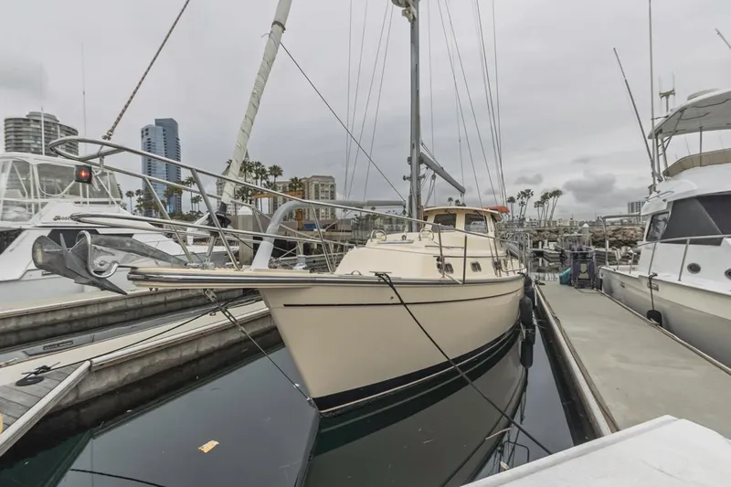 Seeker Yacht Photos Pics 2007 Island Packet SP Cruiser docked at marina, overcast sky, urban skyline background.