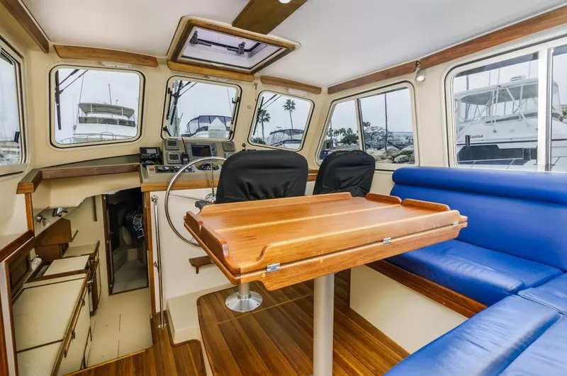 Seeker Yacht Photos Pics 2007 Island Packet SP Cruiser interior with wooden table, blue seating, and navigation area.