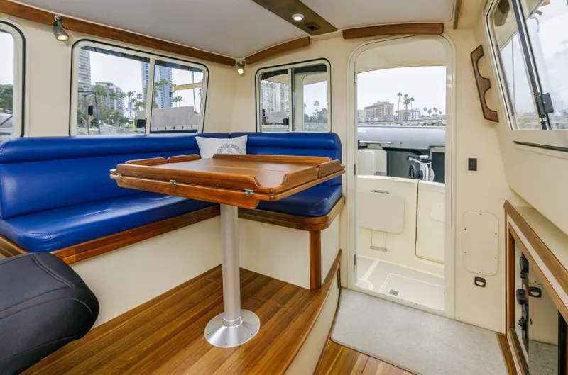 Seeker Yacht Photos Pics 2007 Island Packet SP Cruiser interior with blue seating and wooden table.