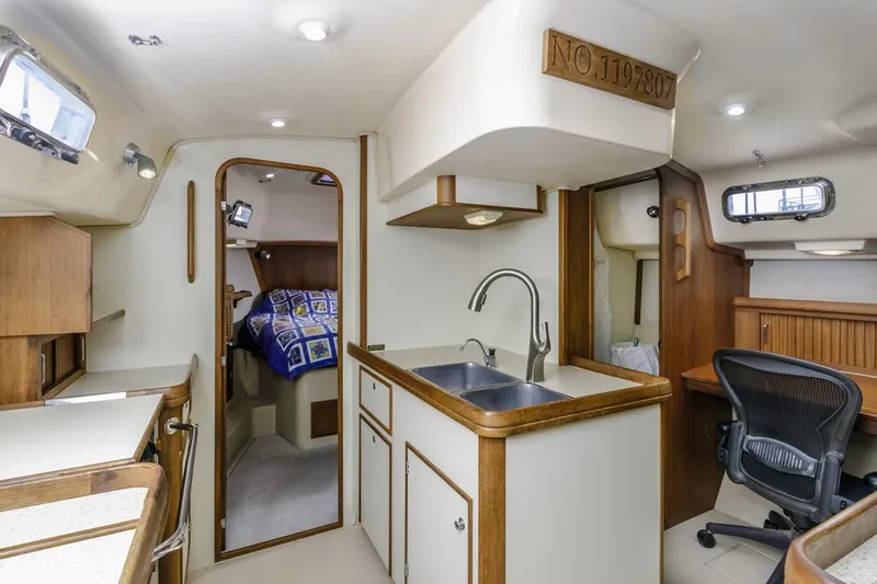Seeker Yacht Photos Pics 2007 Island Packet SP Cruiser interior with kitchen, sink, and cozy sleeping area.