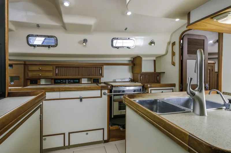 Seeker Yacht Photos Pics Interior of 2007 Island Packet SP Cruiser yacht kitchen with modern amenities and wooden cabinetry.