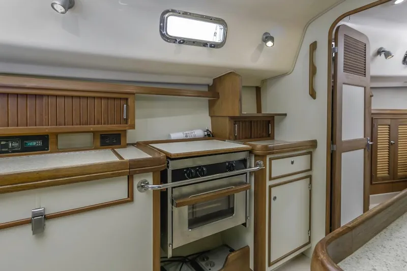 Seeker Yacht Photos Pics 2007 Island Packet SP Cruiser kitchen with wood cabinetry and built-in oven.