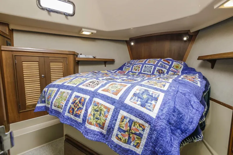 Seeker Yacht Photos Pics Cozy cabin interior of 2007 Island Packet SP Cruiser with colorful quilted bedspread.