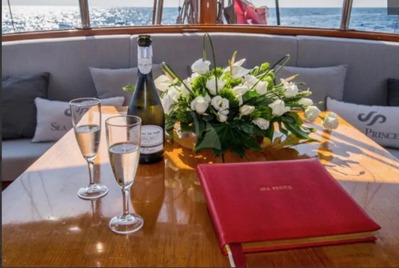 Sea Prince Yacht Photos Pics Luxurious yacht table setting with champagne, flowers, and sea view on a 1953 Abeking & Rasmussen Motor Sailer.