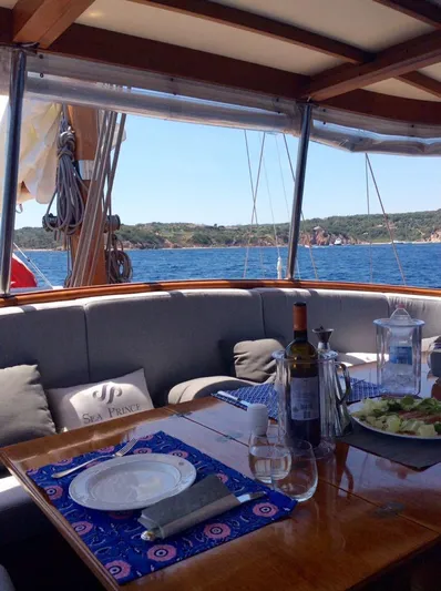 Sea Prince Yacht Photos Pics Luxurious 1953 Abeking & Rasmussen motor sailer with elegant dining setup and scenic ocean view.