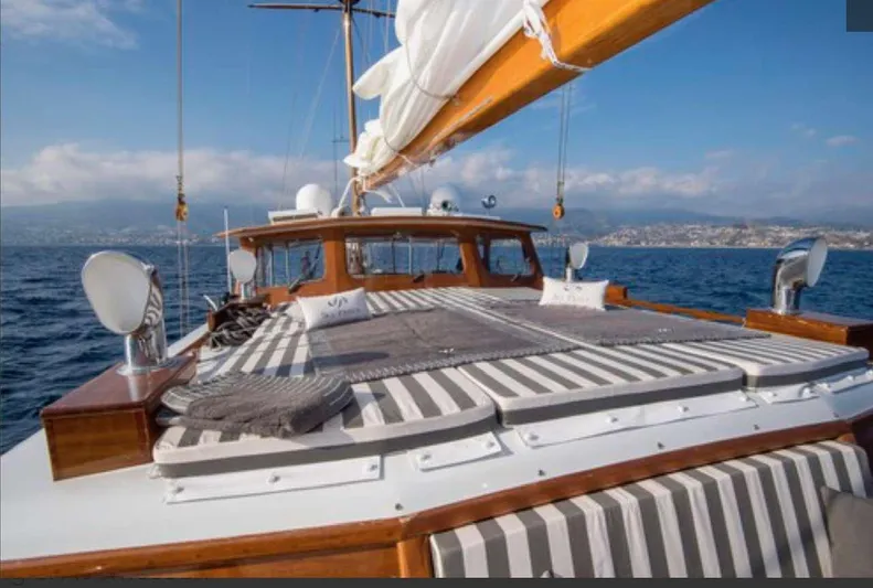 Sea Prince Yacht Photos Pics 1953 Abeking & Rasmussen Motor Sailer on open sea, featuring striped deck cushions.