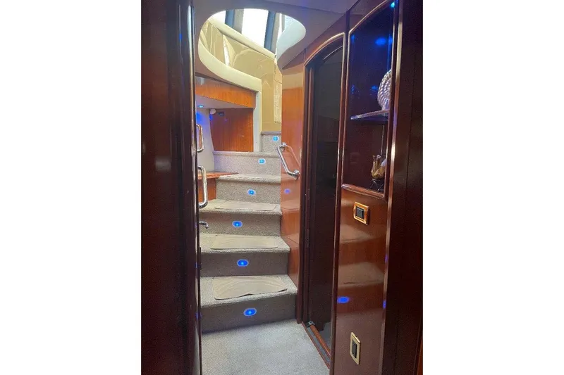  Yacht Photos Pics Interior of 2004 Carver 570 Voyager Pilothouse with illuminated staircase and wooden cabinetry.
