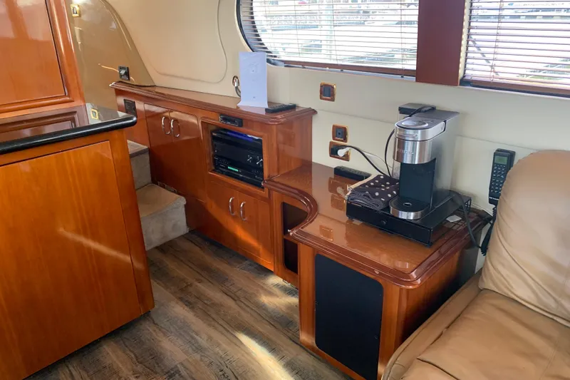  Yacht Photos Pics Interior of 2004 Carver 570 Voyager Pilothouse with wooden cabinetry and coffee maker.
